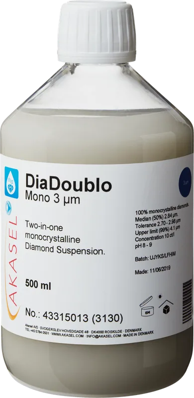 Akasel DiaDoublo Mono 3 µm: En 500 ml plastflaska med vit skruvkork, innehållande en ljus, mjölkvit monokristallin diamantsuspension. Etiketten visar produktnamnet “DiaDoublo Mono 3 µm” tillsammans med beskrivningen “Two-in-one monocrystalline Diamond Suspension.” Ytterligare detaljer inkluderar: “100% monocrystalline diamonds,” “Median (50%) 2.84 µm,” “Tolerance 2.7 – 2.98 µm,” “Upper limit (99%) 4.1 µm,” en koncentration på “10 ct/l,” och ett pH-värde på “8 – 9.” Symboler på etiketten anger lagringsförhållanden och hållbarhet.