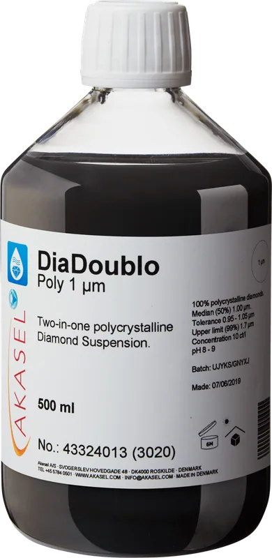 Akasel DiaDoublo Poly 1 µm: En 500 ml plastflaska med vit skruvkork, innehållande en svart 2-i-1 polykrystallin diamantsuspension. Etiketten visar produktnamnet “DiaDoublo Poly 1 µm” tillsammans med beskrivningen “Two-in-one polycrystalline Diamond Suspension.” Ytterligare detaljer inkluderar: “100% polycrystalline diamonds,” “Median (50%) 1.00 µm,” “Tolerance 0.95 – 1.05 µm,” “Upper limit (99%) 1.7 µm,” med en koncentration på 10 ct/l och ett pH-värde på 8–9. Lagringsförhållanden anges med symboler, tillsammans med batchnummer och tillverkningsdatum.